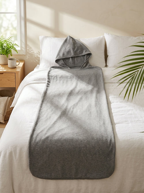 The Hooded Cocoon Blanket laid out on a bed
